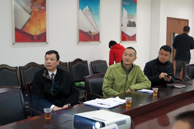 图6、寓目幻灯片的同时，ag亚娱集团仿古砖副总曹坚贞（右一）特殊用手机记下专卖店装修效果的差别亮点